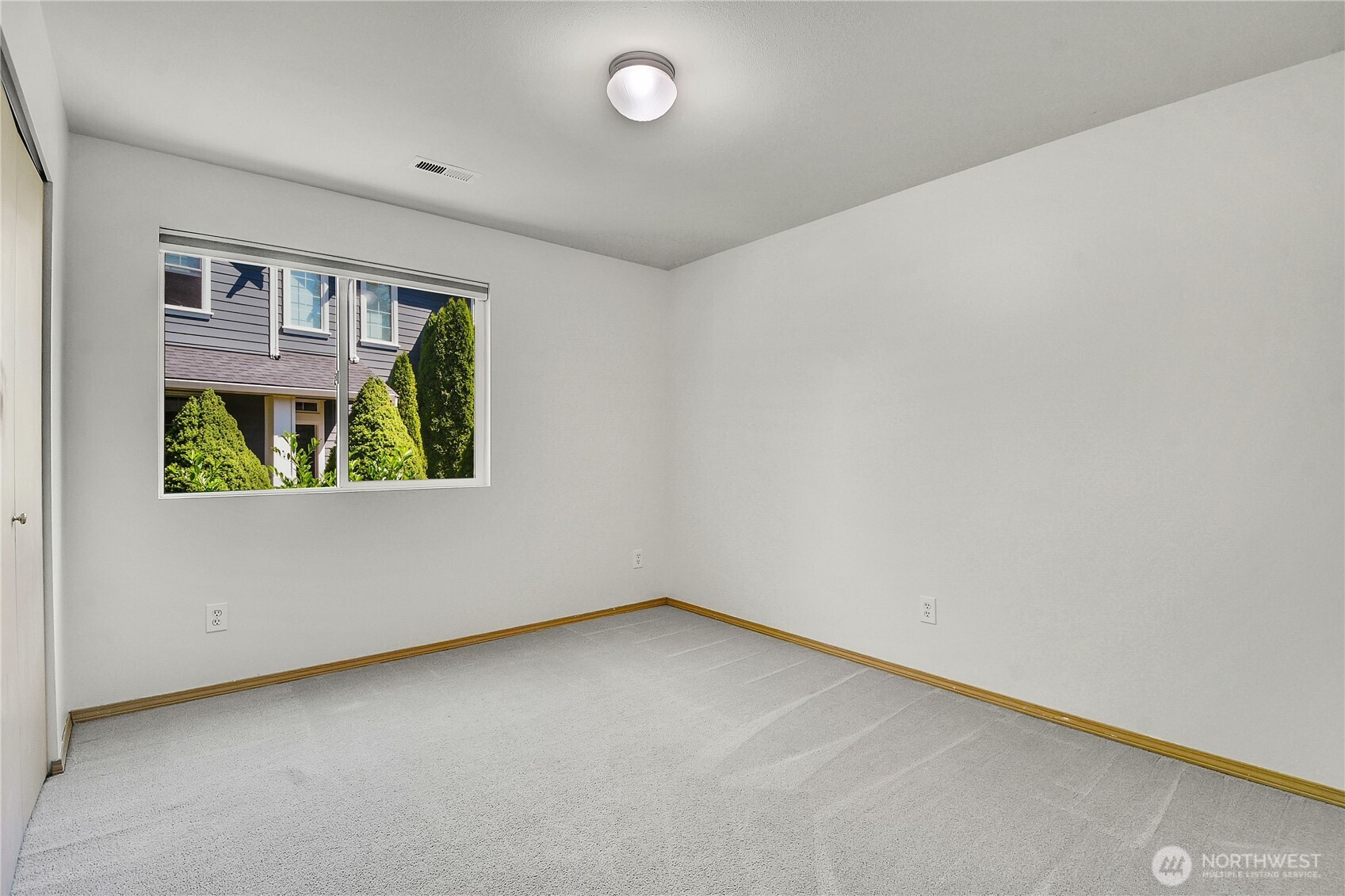Middle bedroom. Neutral carpet. Window with screen and pulldown shade. Closet with bi-fold doors, built-in closet organizers with drawers.